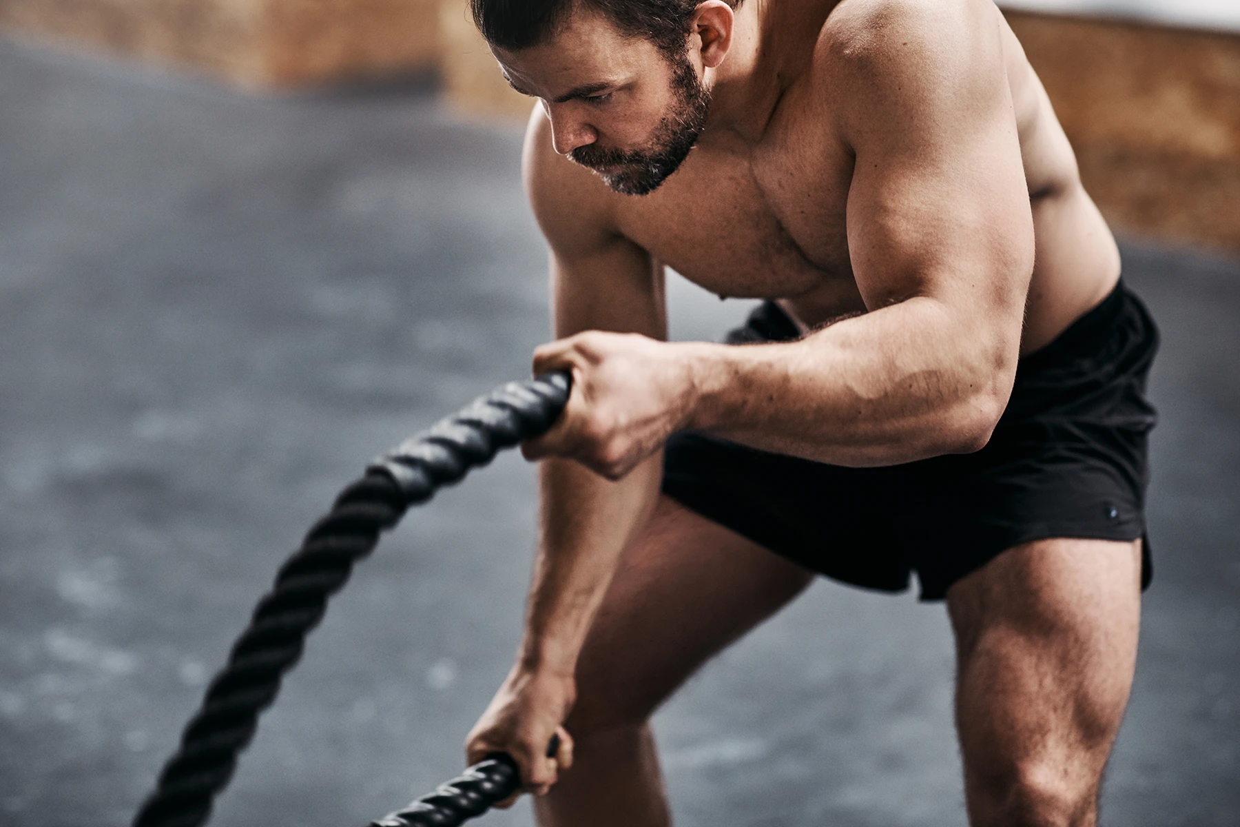 Muscular young man working out with ropes at the gym - stock photo