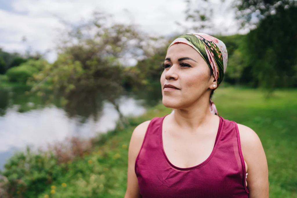 Mature woman who is battling cancer taking a peaceful moment at park - stock photo
