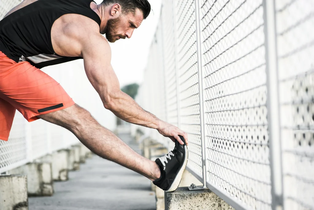Male runner stretching after workout - stock photo
