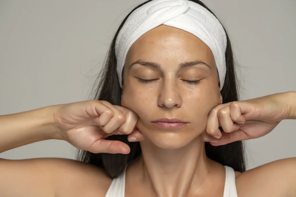 Woman massaging her face - stock photo