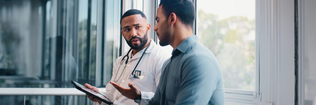 Doctor, men and patient with tablet, advice and hospital for wellness, consultation and medical feedback. People, healthcare and touchscreen with report, news and review info on application at clinic