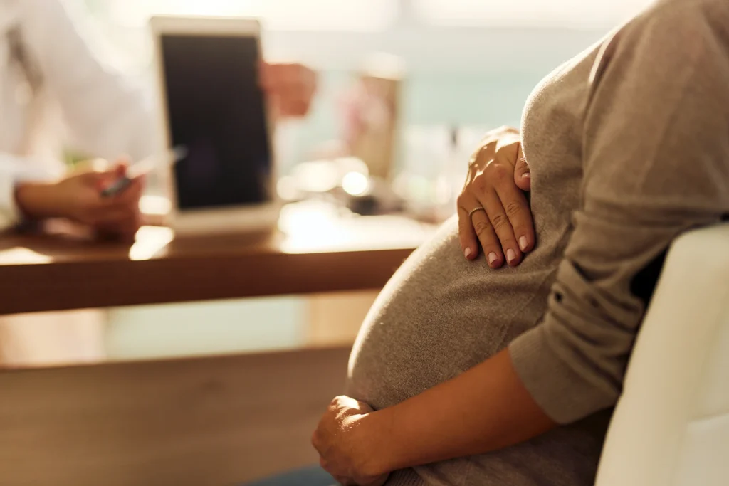 Close up of unrecognizable pregnant woman having an appointment at her gynecologists. - stock photo