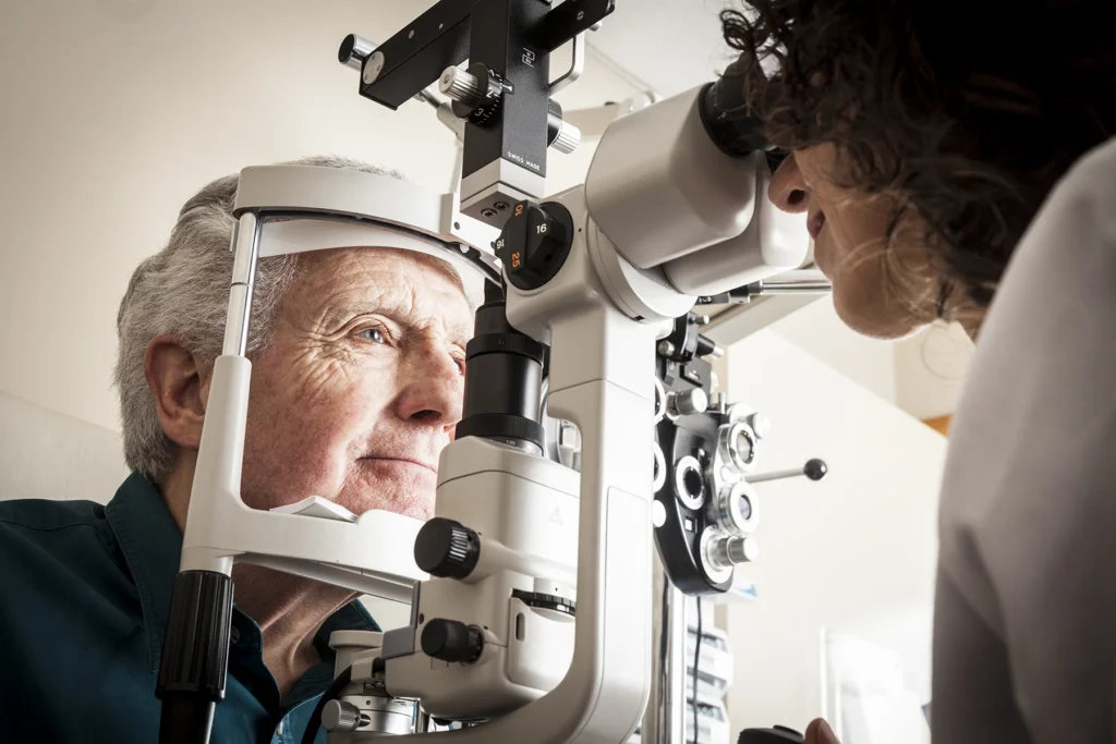 Elderly man gets eye test from an opthalmologist.