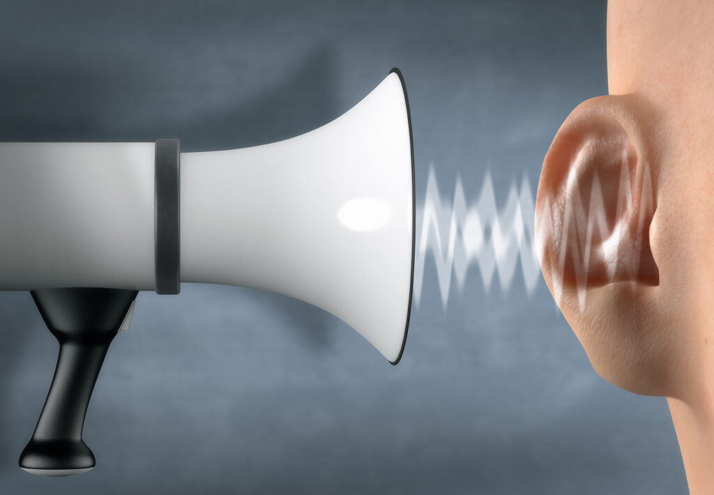 Megaphone yelling in front of an ear - stock photo