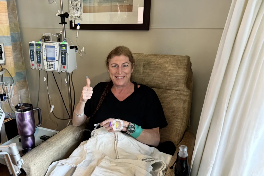 Angela Keim smiles while receiving chemo at Sylvester Comprehensive Cancer Center.