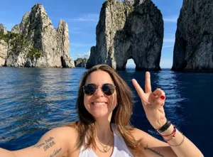 Sylvester cancer patient and uterine sarcoma survivor hopes women proactively look after their own health. Poses on vacation in front of rock formations in the ocean.