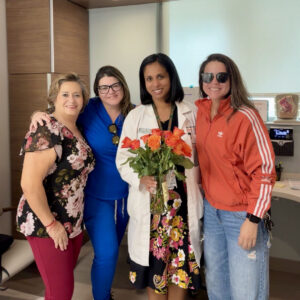Claudia Pereira poses with Dr. Nair and team after giving her flowers.