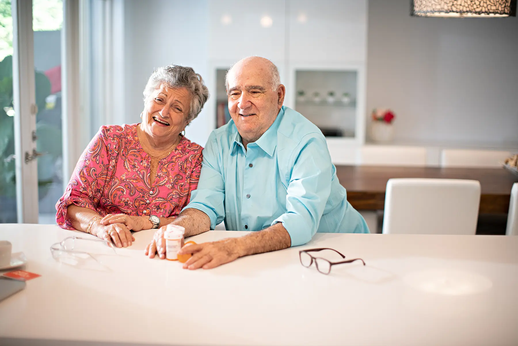 Hispanic senior couple at home with their pills - stock photo