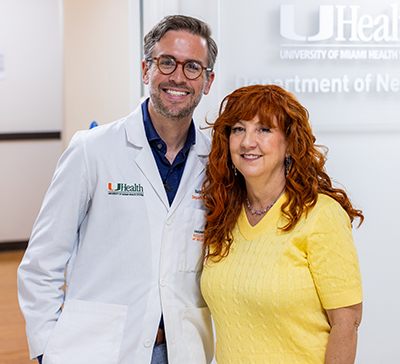 Dr. Nathan Carberry and Amanda Sifford stand together in the Department of Neurology at UHealth, posing for a photo.