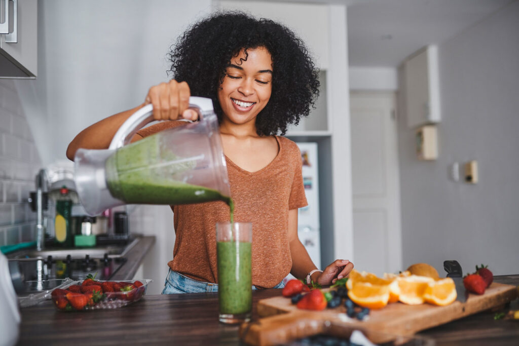 Shot of a young woman making a healthy smoothie at home