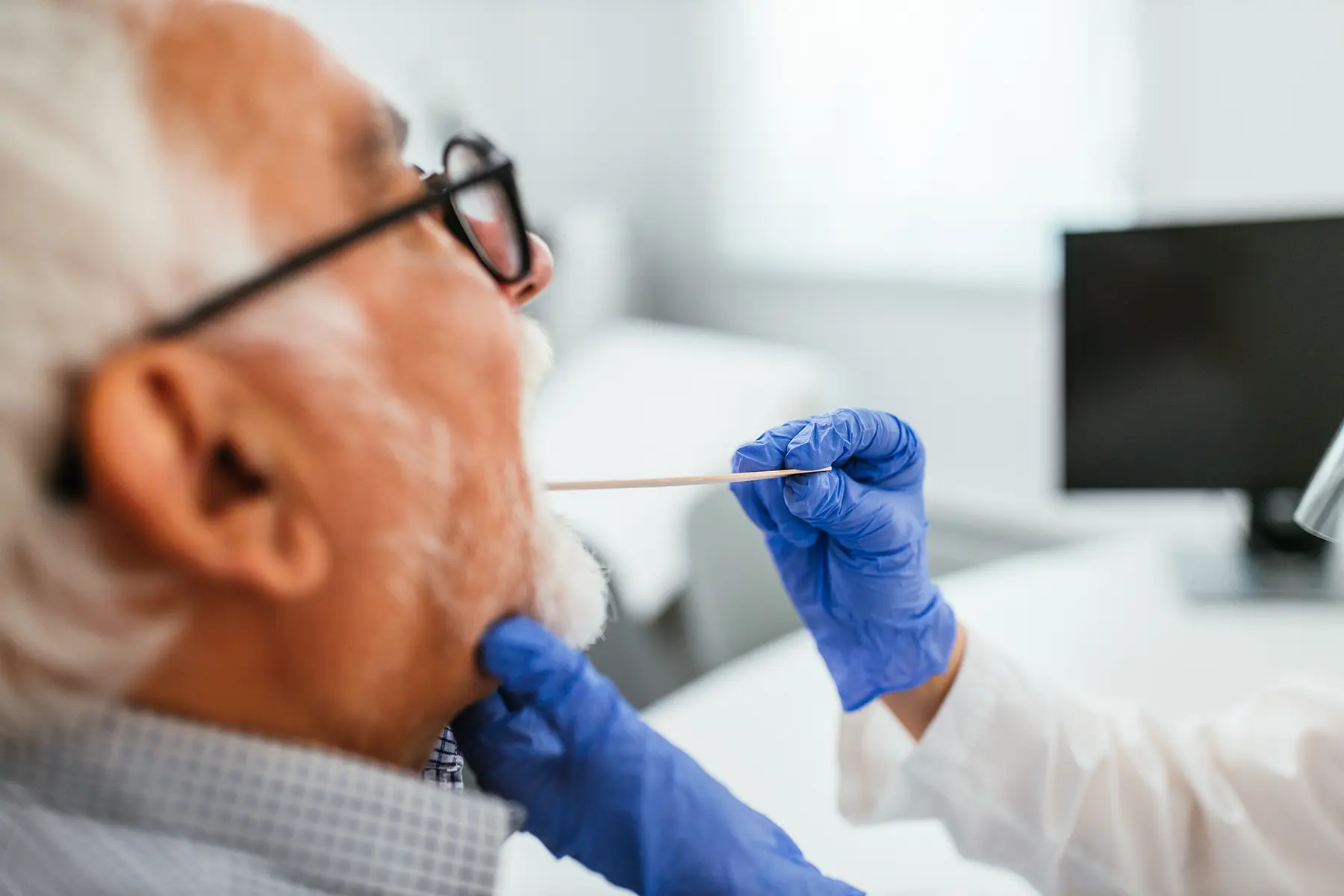 Tounguw swab on senior man. Getty image model