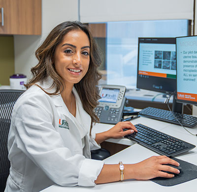 Dr. Raveen Syan works at a computer workstation in a clinical office at the Desai Sethi Urology Institute.